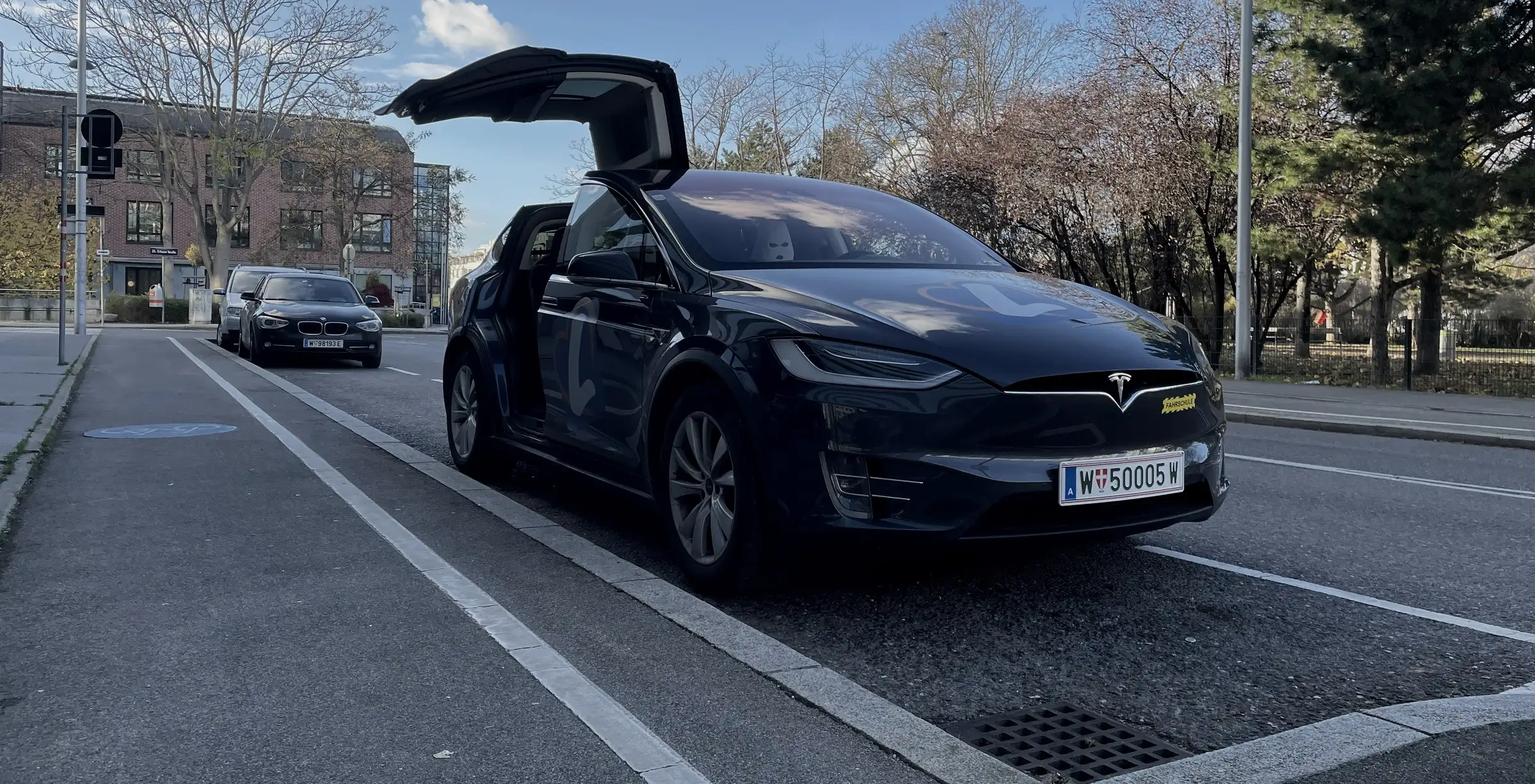 Tesla Model X der Fahrschule Führerschein-Now mit geöffneten Flügeltüren am Erlaaer Platz in Wien